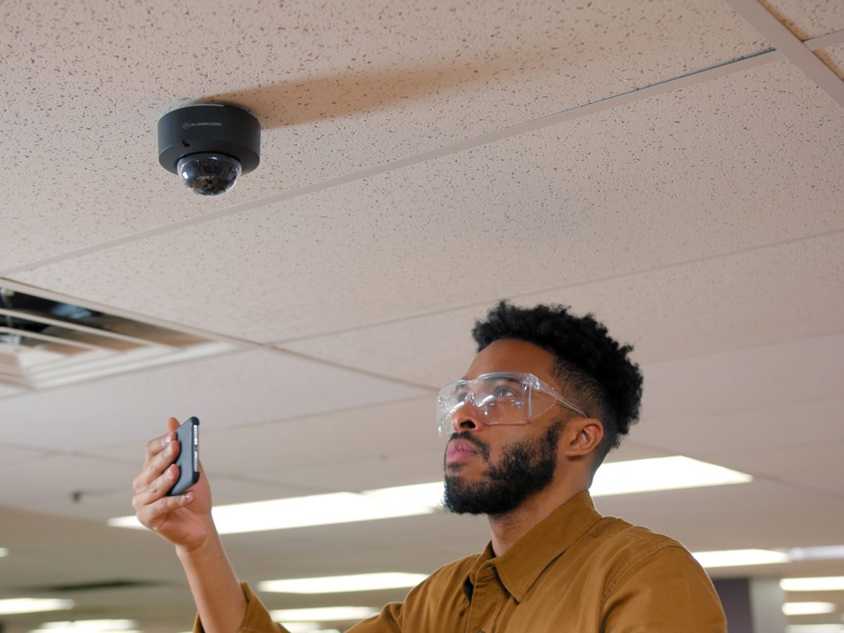 Alarm.com commercial dome camera on a drop ceiling, being aimed from the mobile app