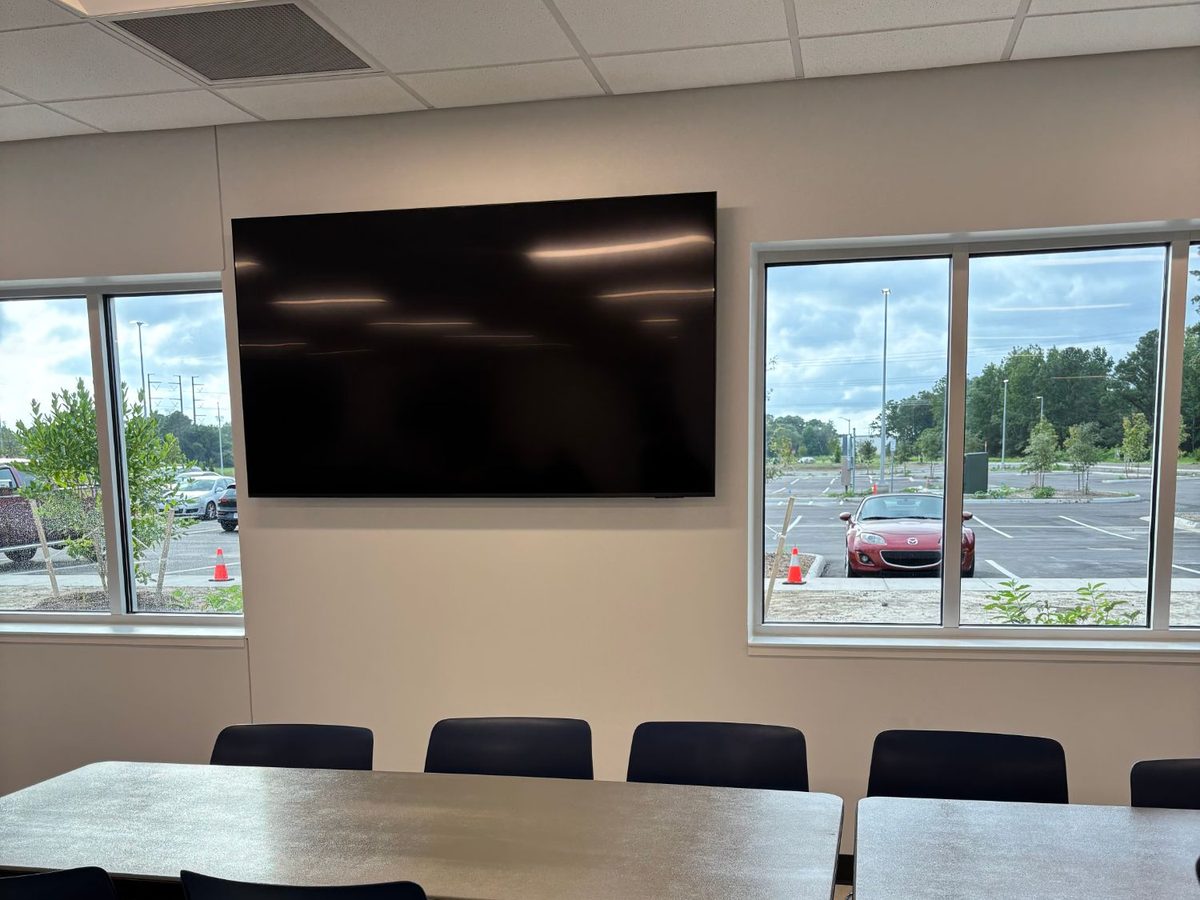 Large display wall-mounted between windows in an office break room
