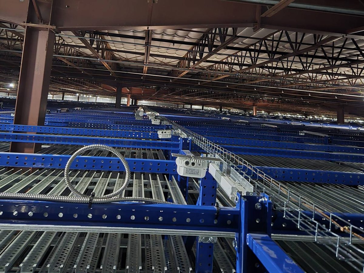 Devices mounted along a basket cable tray run on warehouse racking